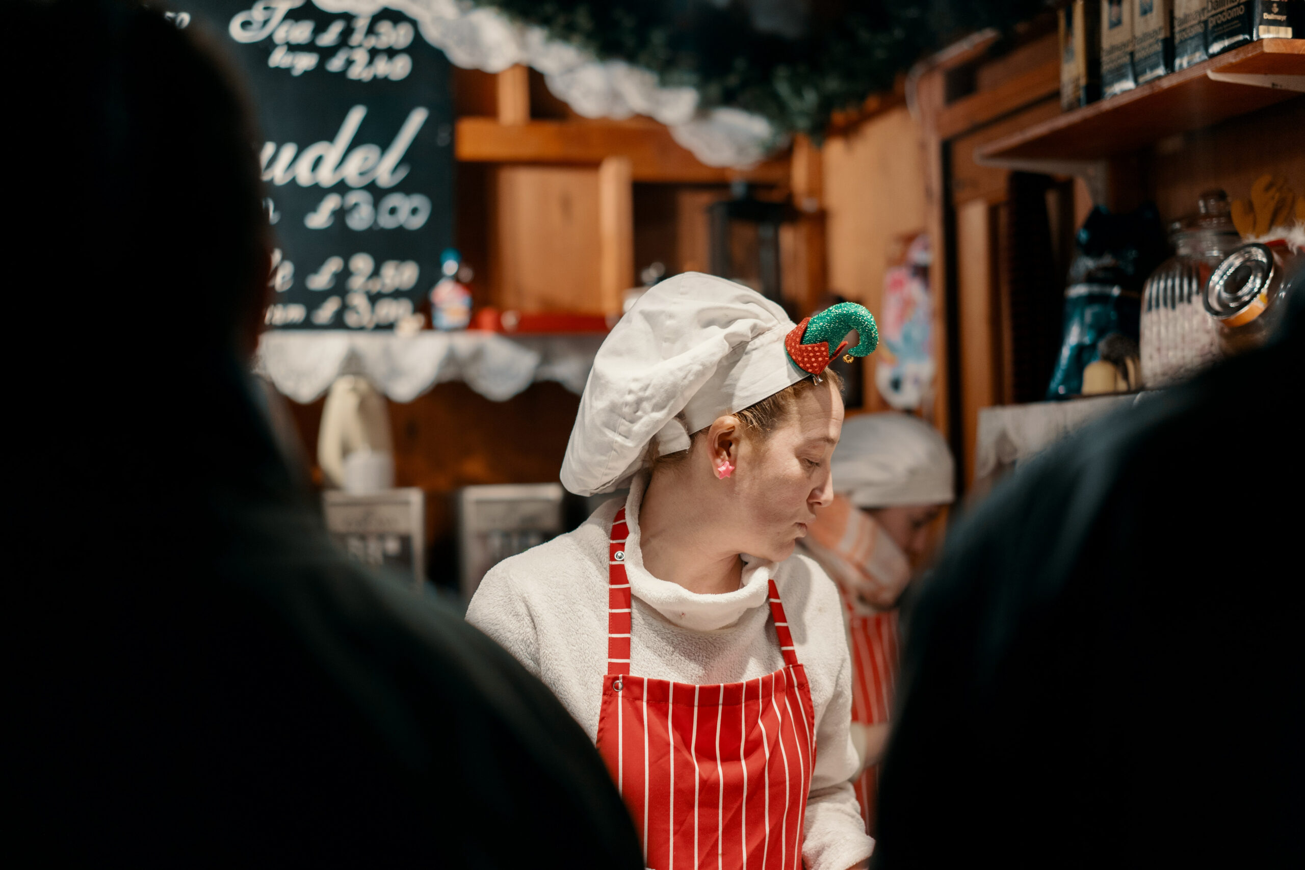 Things to do in East Cambridgeshire - Ely Market - image of stall working in festive headband looking down